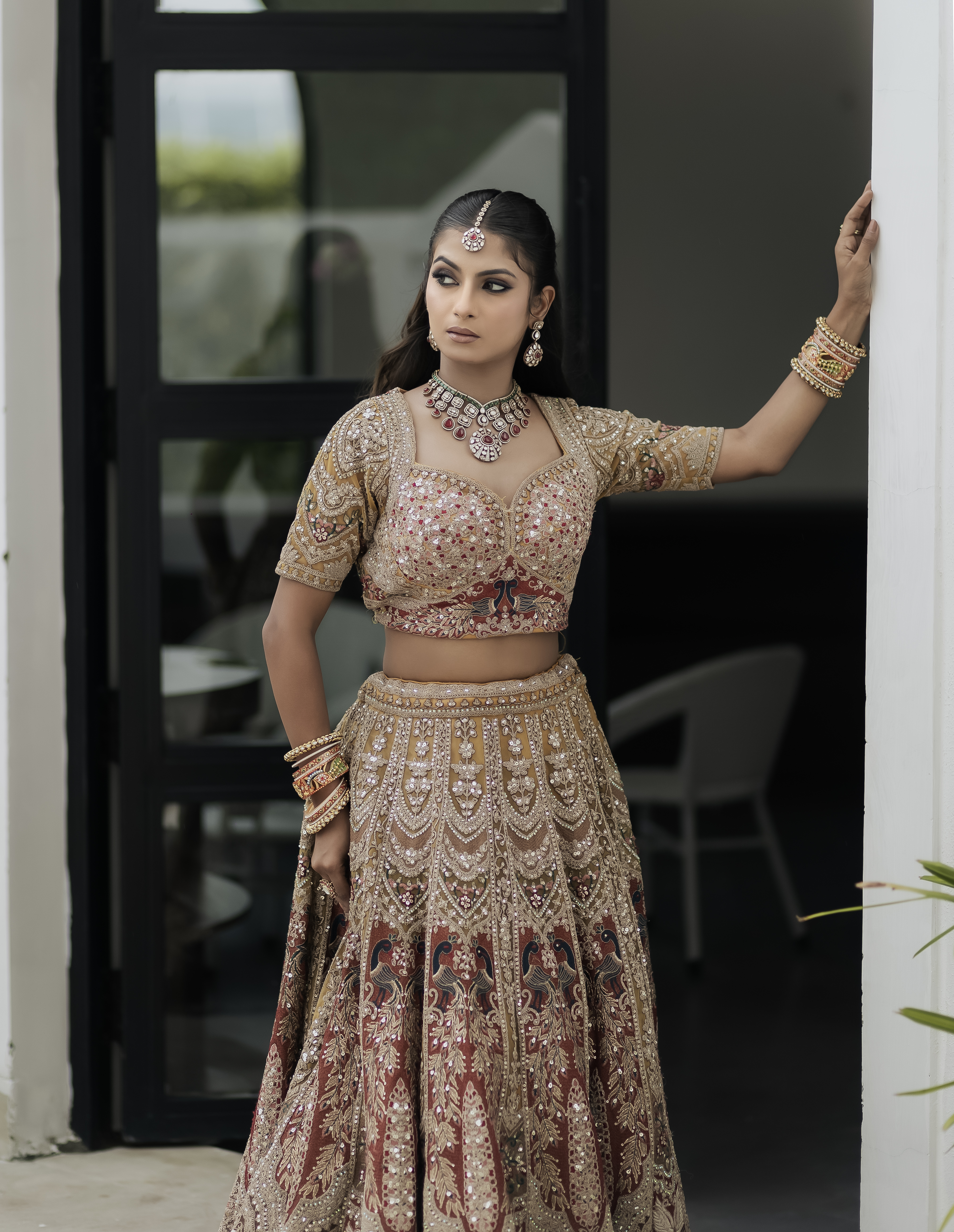 Real bride full portrait in golden bridal lehenga and heavy kundan emerald jewelry
