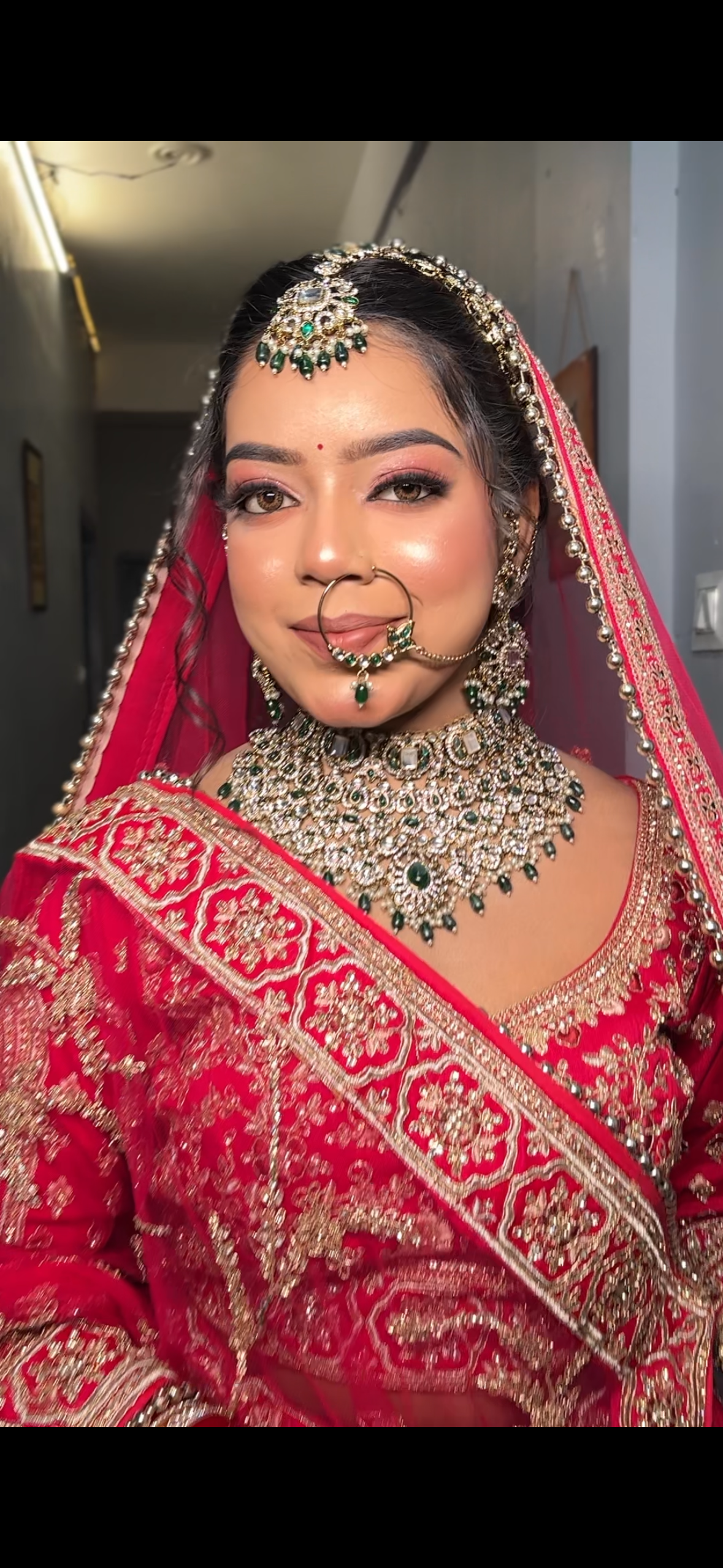 Bride in traditional crimson red lehenga with royal kundan choker, bridal makeup by Shreya Chaudhary